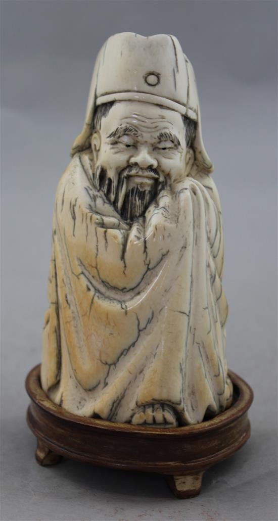 A Chinese mammoth ivory tusk carving of a seated figure of Li Bai, 20th century, 14cm, wood stand